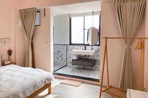 1 dormitorio con lavabo y espejo en Casa de Jumbo en Anping