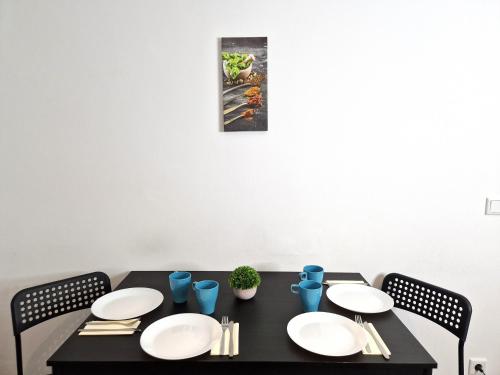 a black table with white plates on it at Meribu H1 Wohnung für Monteure und Arbeiter in Gelsenkirchen