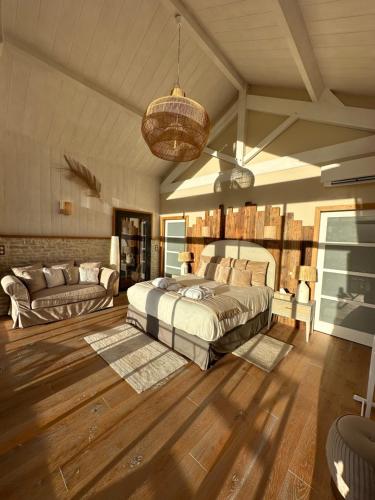 a bedroom with a bed and a couch at Rêverie en Périgord du Domaine des Hauts de Rouquette in Eymet