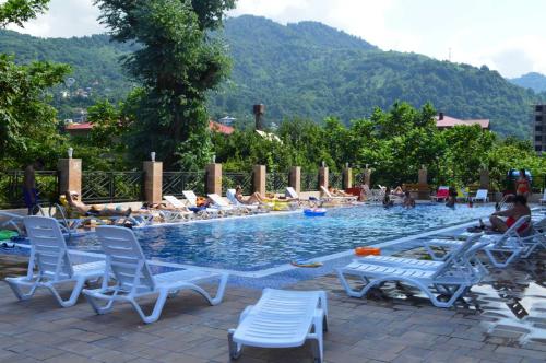 a pool with lounge chairs and people laying in the water at Euro Palace Gonio in Gonio