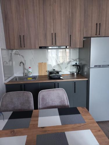 a kitchen with a table and a white refrigerator at Euro Palace Gonio in Gonio