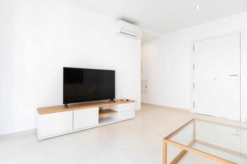 a living room with a flat screen tv on a white wall at Roses Casc Antic Sl Sabater 4 in Roses