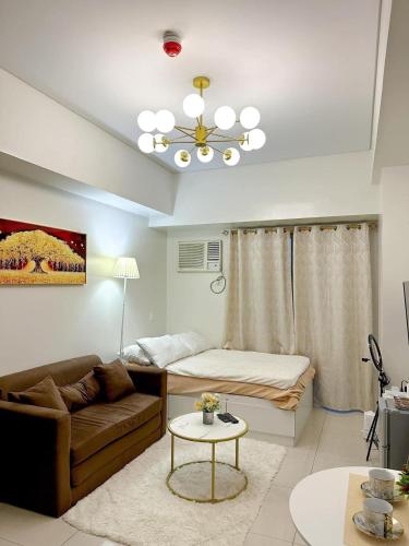 een woonkamer met een bank en een bed bij The Olive Place in Manilla