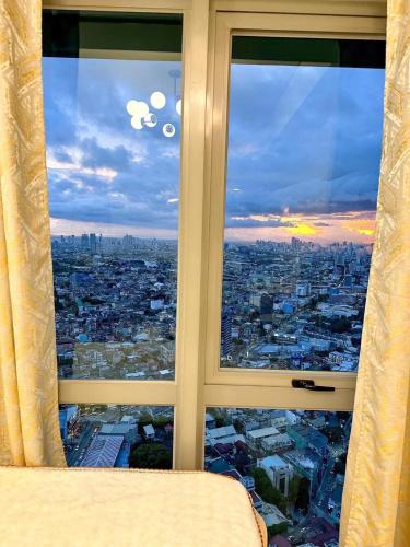 een raam met uitzicht op de stad bij The Olive Place in Manilla