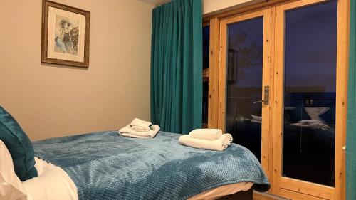 LamlashにあるBayview Cottageのベッド1台にタオル2枚が備わる客室です。