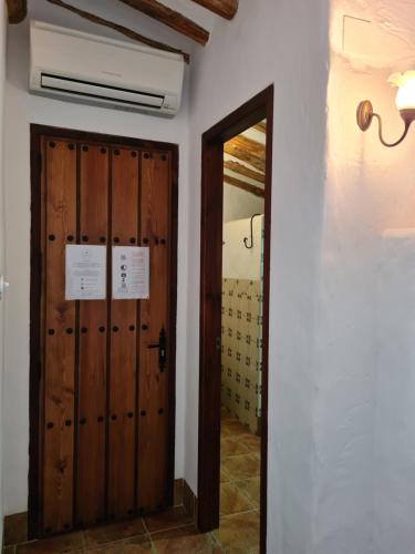 a hallway with a door and a mirror at La Posada Amena in Carcabuey
