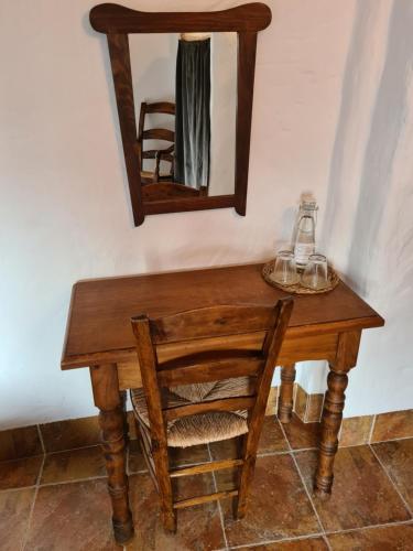 a wooden table with a mirror and a chair on it at La Posada Amena in Carcabuey