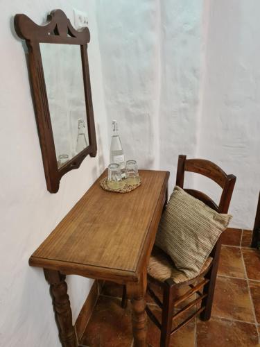 a wooden table with glasses and a bottle on it at La Posada Amena in Carcabuey