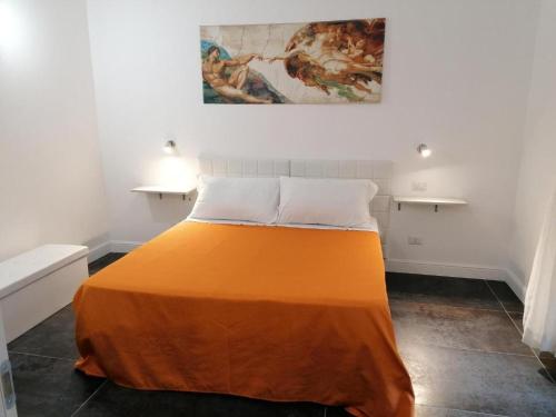 un letto con una coperta arancione in una stanza di Le Stelle Dell'Esquilino a Roma