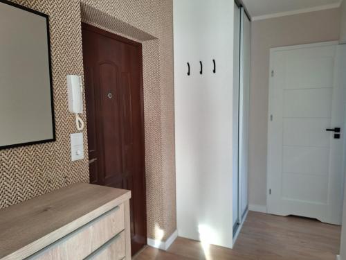 a room with a wooden door and a mirror at Apartament Kamienny Potok Sopot in Sopot