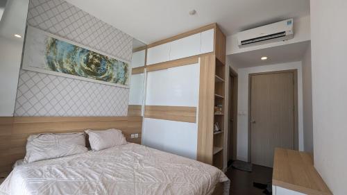 - une chambre avec un lit et une peinture murale dans l'établissement The Prince - 2 bedrooms condominium in Phu Nhuan, à Hô-Chi-Minh-Ville