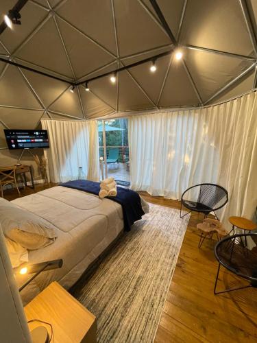 a bedroom with a large bed in a tent at GOAT LODGE Domo Pitanga in Ibiúna