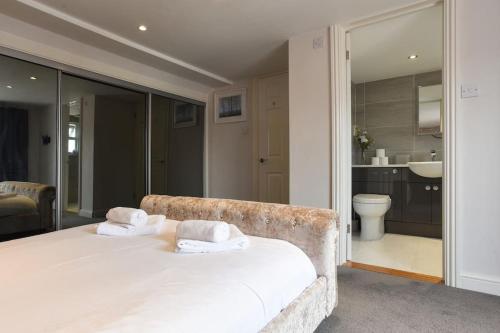1 dormitorio con 1 cama con toallas en Spacious 4-Bed Family House, en Portsmouth