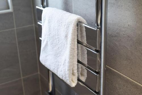 a towel hanging on a towel rack in a bathroom at Spacious 4-Bed Family House in Portsmouth