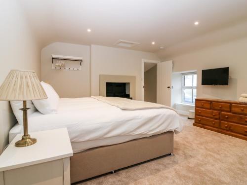 um quarto com uma cama grande e uma televisão em 8 Barney Mains Cottage em Haddington
