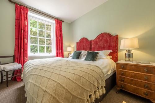 a bedroom with a large bed and a window at East Wing Apartment in Wymondham