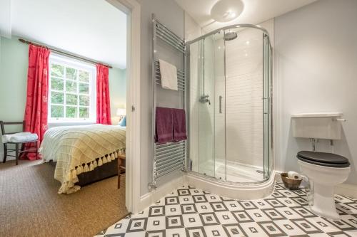 a bedroom with a shower and a bed and a toilet at East Wing Apartment in Wymondham