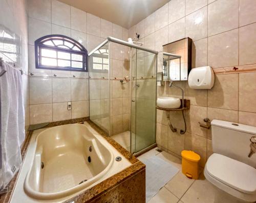 y baño con bañera, ducha y aseo. en Casa de campo c vista para a Lagoa de Saquarema RJ, en Saquarema