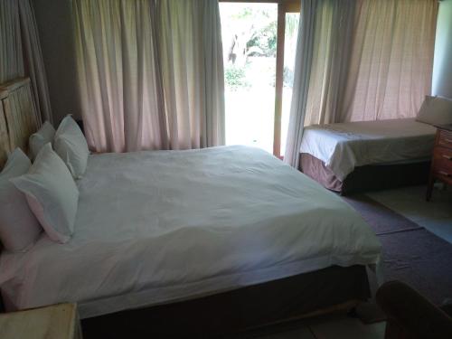 pokój hotelowy z łóżkiem i oknem w obiekcie HLULALA GUEST HOUSE w mieście Hluhluwe