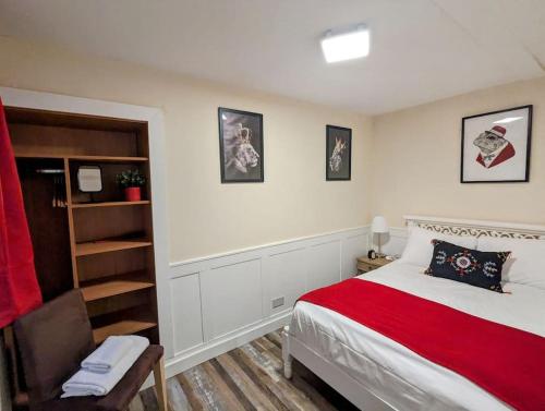 um quarto com uma cama e uma cadeira em The Cwtch Flat at The Lodge by Cefn Tilla em Usk
