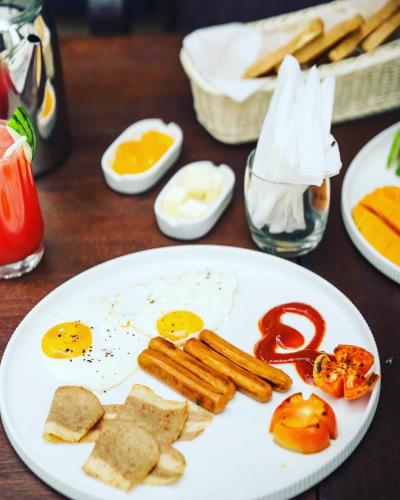 a plate of breakfast food with eggs sausage and tomatoes at Sunset Villa in Waskaduwa