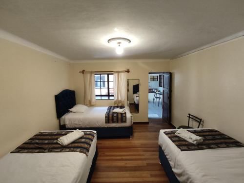 Cette chambre comprend 2 lits et un miroir. dans l'établissement Qosqo Apartments 3, à Cusco