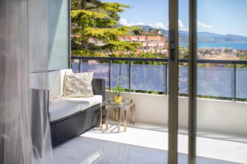 d'un balcon avec un banc et une vue sur la ville. dans l'établissement Magnifique studio limitrophe Monaco, parking privé, à Roquebrune-Cap-Martin