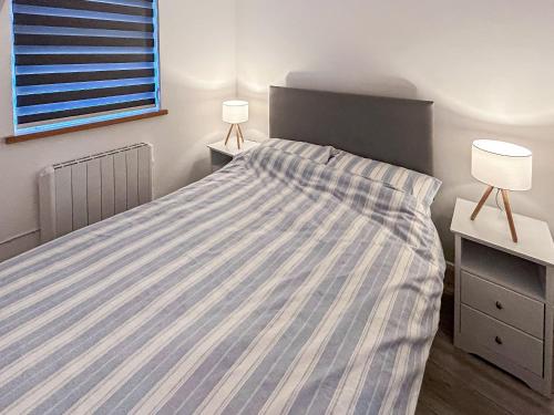 a bedroom with a bed with a striped bedspread at Elmrise Park in Llangain