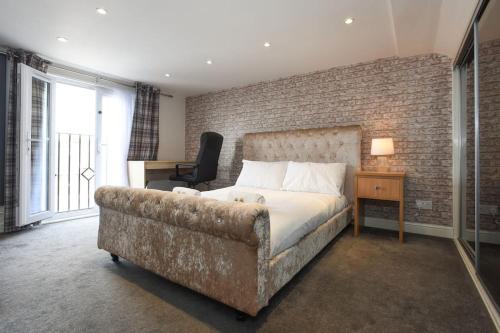a bedroom with a bed and a couch at Spacious 4-Bed Family House in Portsmouth