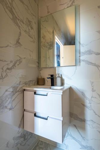 - une cuisine avec des comptoirs blancs et un mur en marbre dans l'établissement 304 B Charming 2 room apartment refurbished super, à Nice