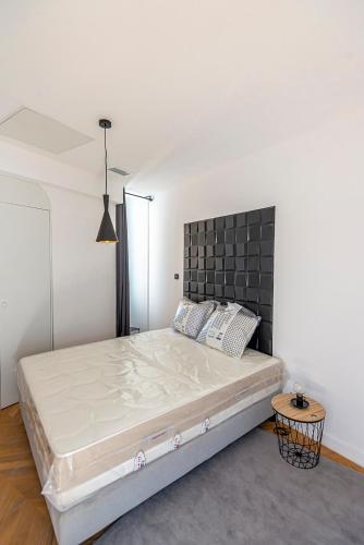 une chambre avec un grand lit avec une tête de lit noire dans l'établissement 304 B Charming 2 room apartment refurbished super, à Nice
