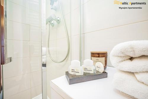 a bathroom with white towels and a shower at Baltic Apartments - Apartamenty Aquamarina in Świnoujście