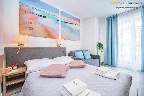 a bedroom with a large bed with pillows on it at Baltic Apartments - Apartamenty Aquamarina in Świnoujście