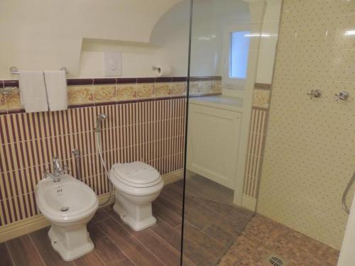 uma casa de banho com um WC e uma cabina de duche em vidro. em Le Piccole Lune di Monti em Roma