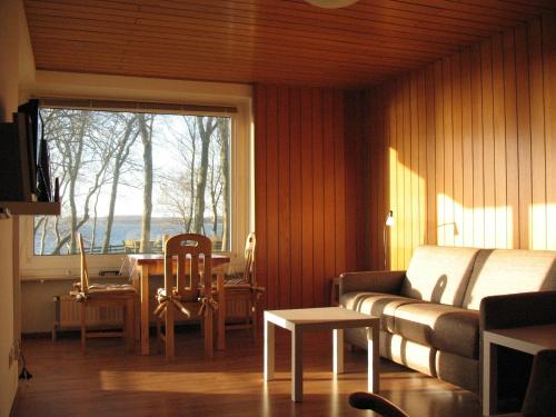 - un salon avec un canapé, une table et une fenêtre dans l'établissement Ferienwohnung Am Leuchtturm, à Schausende
