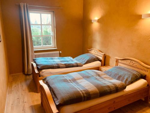 two beds sitting in a room with a window at Ferienhaus Boddinsfelde in Mittenwalde