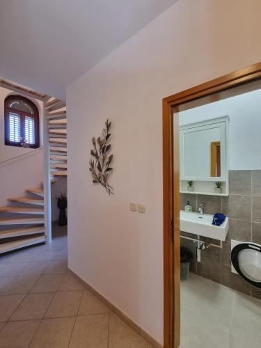 a bathroom with a sink and a staircase at Cherry House in Višnjan