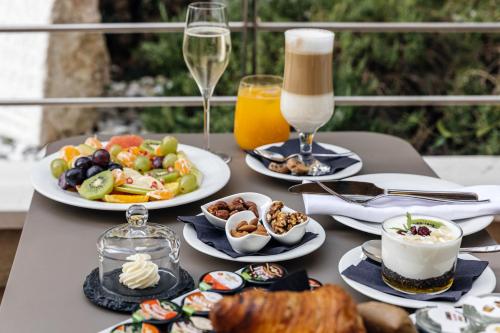 a table with plates of food and glasses of wine at Armerun Heritage Hotel & Residences in Šibenik