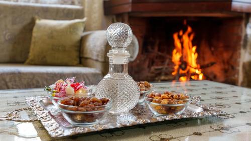 a tray with three bowls of food on a table with a fireplace at Petrino House Lasithi in Agios Georgios