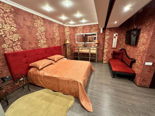 a bedroom with a red bed and a red chair at Hotel Nika in Chornomorsk