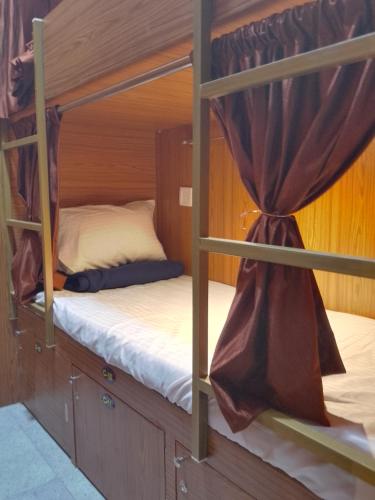 two bunk beds in a small room with curtains at Kufa PG Dormitory in Mumbai