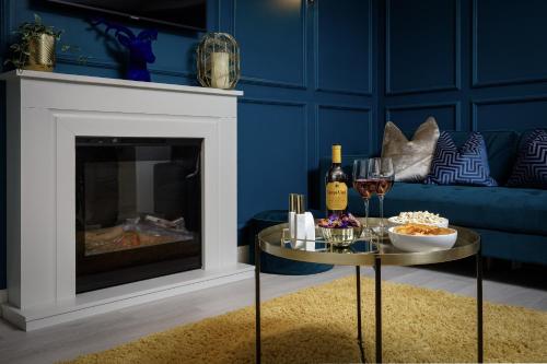 a living room with a fireplace and a table with wine glasses at Belverdale by STAMP SA in Blackpool