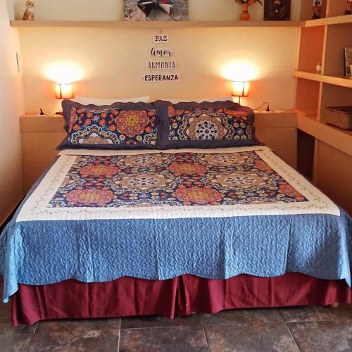 a bedroom with a bed with a colorful bedspread at Apart , Descanso y Bienestar in San Pedro
