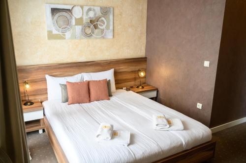 a hotel room with a bed with two towels on it at MV Monogram in Inđija