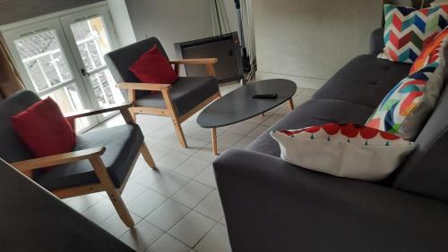 a living room with two couches and a table at La Mansarde in Saint-Émilion