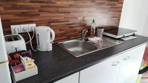 a kitchen with a sink and a counter top at La Mansarde in Saint-Émilion