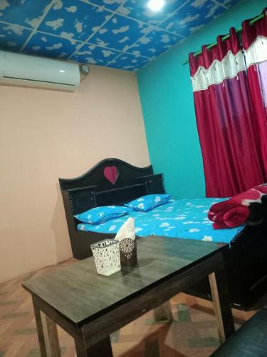 a bedroom with a bed and a table with a table at Dreams restaurant and lodge in Maruwā Ghāt