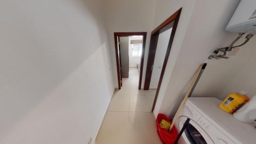 a hallway leading into a room with a laundry room at St Julians - Balluta 2 bedroom apartment in St. Julianʼs