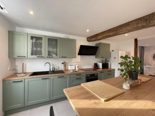 夏布利的住宿－L'Authentique，厨房配有绿色橱柜和木桌