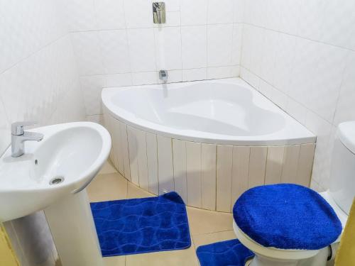a bathroom with a sink and a toilet and a tub at Wangu Apartments in Livingstone